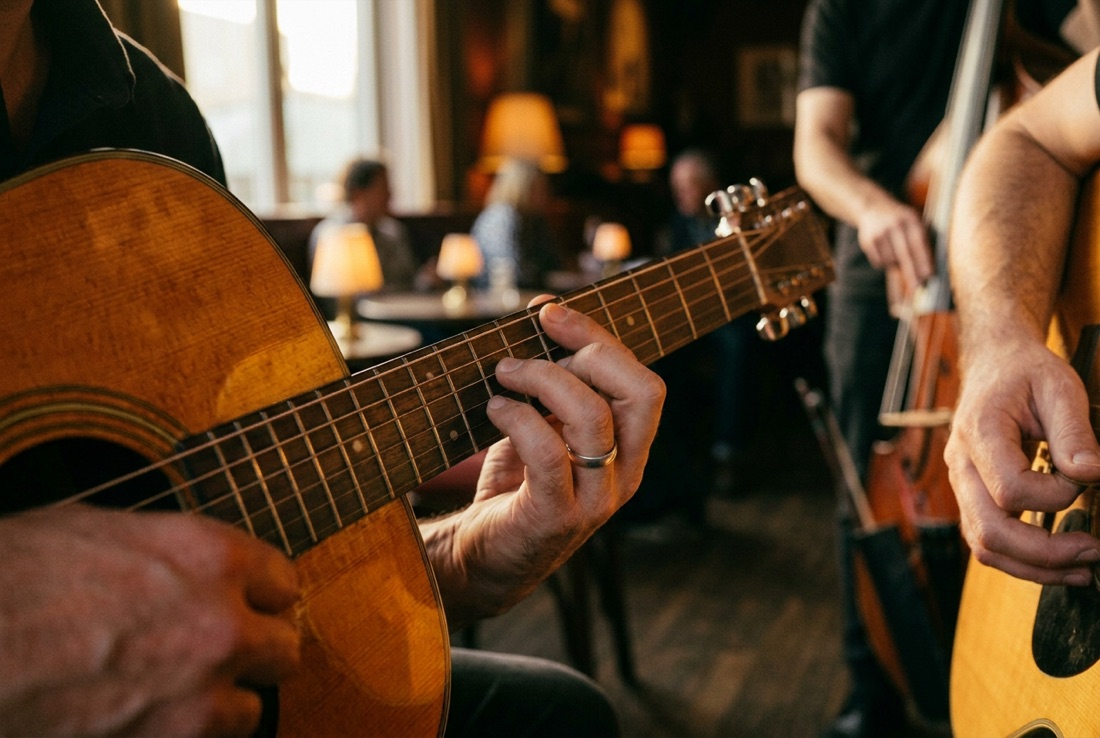 Close-up of two hands pressing a chord on an acoustic guitar in a warm room